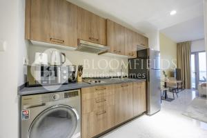 cocina con lavadora y lavavajillas en Bloomfields Snug Stu Oasis Masdar, en Al Wathbah