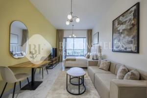 una sala de estar con un sofá y una mesa en Bloomfields Snug Stu Oasis Masdar, en Al Wathbah