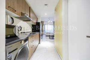 y cocina con lavadora y secadora. en Bloomfields Snug Stu Oasis Masdar, en Al Wathbah