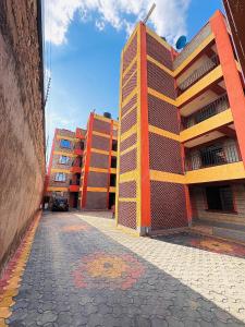 ナイバシャにあるPendeza homesの通りの隣にあるオレンジと黄色の建物2棟