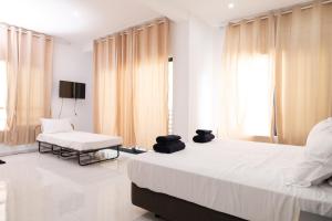 Un dormitorio blanco con dos camas y una silla. en Apart'hotel Assomada, en Assomada