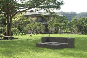 a couch sitting in the grass in front of a house at Seasons Inn in Jiaoxi