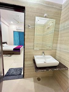 a bathroom with a sink and a mirror at HOTEL GLORY IN Chatha meel,raitha road lucknow in Bhauli