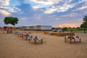- un groupe de personnes dormant sur des lits sur une plage dans l'établissement Helsinki Desert Camp, à Jaisalmer
