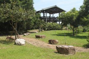 a stone path in the grass with a building in the background at Seasons Inn in Jiaoxi