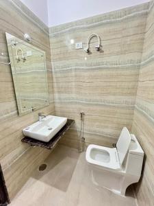 a bathroom with a white toilet and a sink at HOTEL GLORY IN Chatha meel,raitha road lucknow in Bhauli
