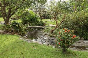 a wooden bridge over a stream in a garden at Seasons Inn in Jiaoxi
