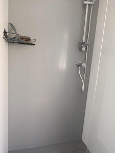 a shower in a bathroom with a white wall at Superbe mobil-home à Seignosse plage in Seignosse +12 photos