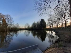 a view of a river with a wooden dock at Lekker knus in de Huismus in Diffelen