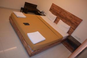 a bedroom with a large bed with a wooden headboard at Hotel Royal Residency in Umele