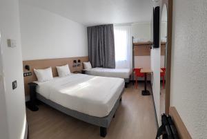 a hotel room with a bed and a desk at B&B HOTEL Thionville Yutz Route du Luxembourg in Basse-Yutz