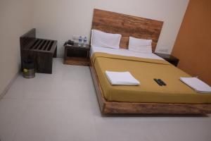 a bedroom with a large bed with a wooden headboard at Hotel Royal Residency in Umele