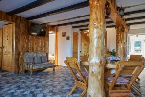 ein Wohnzimmer mit einem Holztisch und Stühlen in der Unterkunft Casa Elder Villa in Bran