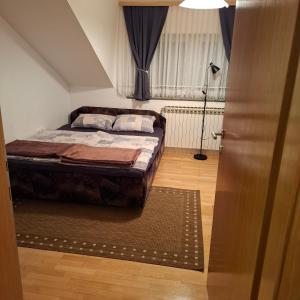 a bedroom with a bed and a lamp and a door at Apartman Anita in Varaždin +26 photos
