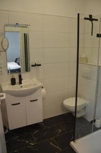 Un baño con lavabo, inodoro y espejo. en Schlafort, en Porta Westfalica 19 fotos más