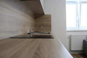 a kitchen with a sink and a wooden floor at KAVE Obchodná Apartments in Bratislava