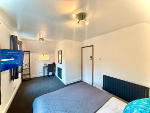 a bedroom with a bed and a flat screen tv at Coastal Lodge in Leiston