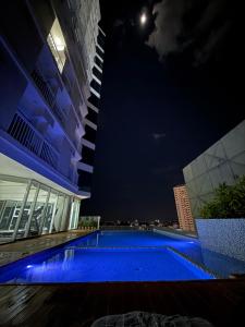 a building with a swimming pool at night at RGM PLACE in Davao City