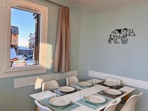 a dining room with a table and chairs and a window at Appartement scandinave rénové, skis aux pieds, 7 pers. - FR-1-634-6 in Avoriaz +8 photos