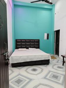 NaimishāranyaMa vindhyavasini Atithi Bhavan的卧室里有一张床，墙壁是蓝色的
