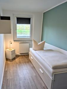 a small bedroom with a bed with a window at Ferienwohnung August 29 in Gelenau