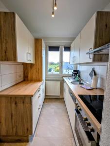 a kitchen with white cabinets and a large window at Ferienwohnung August 29 in Gelenau