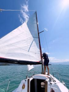 een man die bovenop een zeil op een boot staat bij Veleiro Alpha 22 Privativo in Paraty