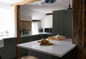 SelhamにあるAmbersham Houseのキッチン(緑のキャビネット、白いカウンタートップ付) +1枚の写真