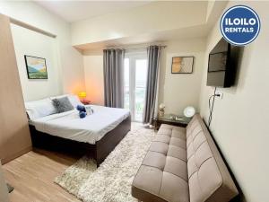 a hotel room with a bed and a couch at Live in style Studio at Saint Dominique in Mandurriao