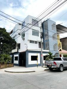 a white building with a car parked in front of it at Golden Suite Miraflores 