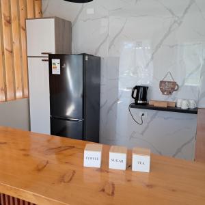 a kitchen with a refrigerator and two price signs on a counter at Tiny House Ruta 215 in Osorno +7 photos