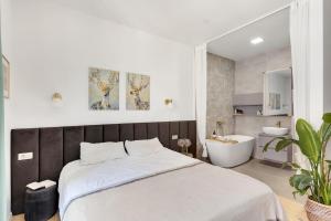 a bedroom with a bed and a tub and a bathroom at Apartment 67 in Rove