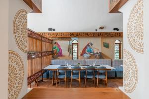 a dining room with a table and chairs and paintings on the wall at Le Casa Lion Resort A Premium Resort In Sasan Gir in Sasan Gir