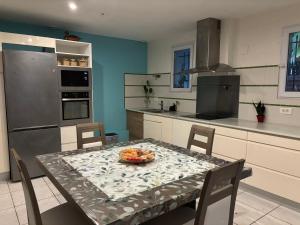 - une cuisine avec une table et une plaque de cuisson dans l'établissement Maison Colibri, à Salies-de-Béarn