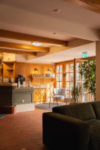 伯布林根族瑞特酒店及餐厅的客厅里有一张沙发和一个厨房