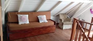 eine Couch in einem Raum mit Treppe und Stuhl in der Unterkunft Rojaiju in Punta del Este