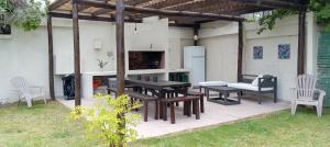 eine Terrasse mit Tisch und Stühlen und einem Kühlschrank in der Unterkunft Rojaiju in Punta del Este