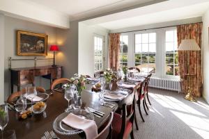 a dining room with a long table and chairs at Butley Priory Farmhouse in Woodbridge