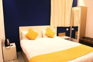 a bedroom with a white bed with yellow pillows at Sunny Ridge Homesty in Cherrapunji