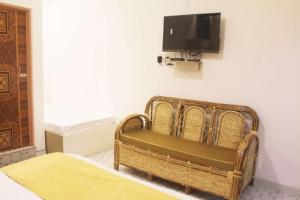 a room with a couch and a tv on a wall at Sunny Ridge Homesty in Cherrapunji