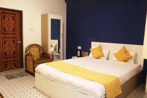 a bedroom with a large bed with yellow pillows at Sunny Ridge Homesty in Cherrapunji +9 photos