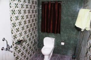 a bathroom with a toilet and a red shower curtain at Sunny Ridge Homesty in Cherrapunji