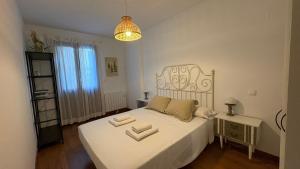 ein Schlafzimmer mit einem weißen Bett mit Handtüchern darauf in der Unterkunft Rincon de Pepo in Villanúa + 12 Fotos