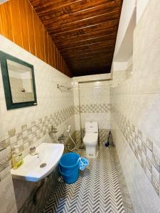 une salle de bain avec un lavabo et des toilettes dans l'établissement Emnic Cottage Homestay, à Meppādi