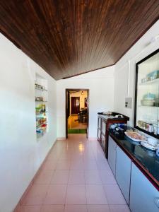 une cuisine avec des murs blancs et un plafond en bois dans l'établissement Emnic Cottage Homestay, à Meppādi