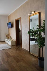 a hallway with a mirror and a potted plant at Villa La Plazza in Dugopolje