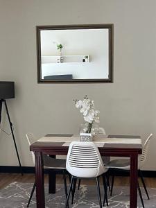 a dining room table with a mirror on the wall at The Happy Nest in Kampala