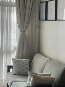 a living room with a white couch and a window at The Happy Nest in Kampala