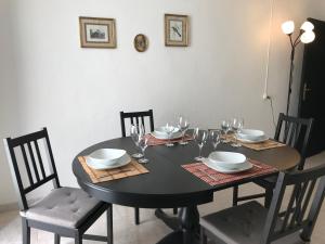 a black dining room table with chairs and glasses on it at Maison traditionnelle à Estremoz in Estremoz