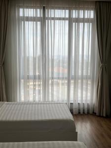 a bedroom with a bed and a large window at The Happy Nest in Kampala